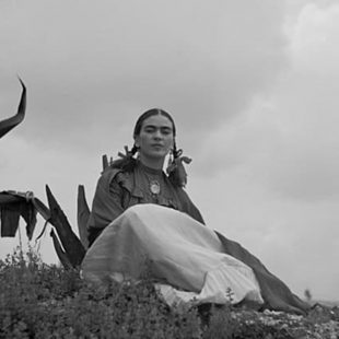 Photo en noir et blanc de Frida Kahlo assise près d'un agave