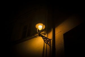 Lampadaire allumé dans une rue sombre