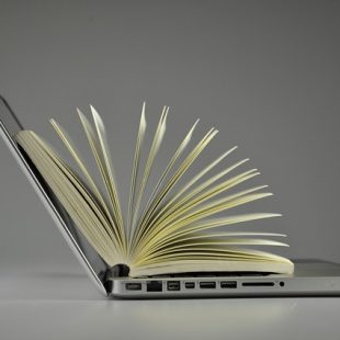 Photo d'un ordinateur avec un livre ouvert