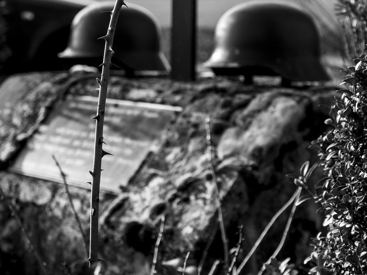 Image de guerre avec des casques de soldats posés sur ce qui pourrait être une tombe