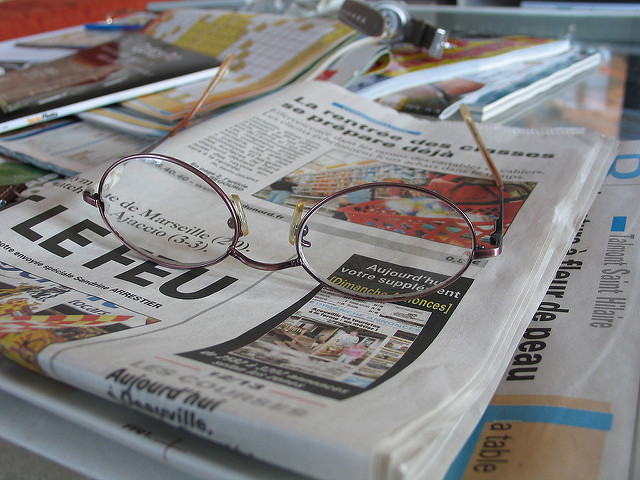 photo en gros plan de journaux et d'une paire de lunettes