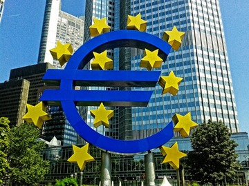 Photomontage d'un euro entouré des étoiles de l'UE devant un building