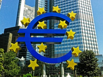 Photomontage d'un euro entouré des étoiles de l'UE devant un building