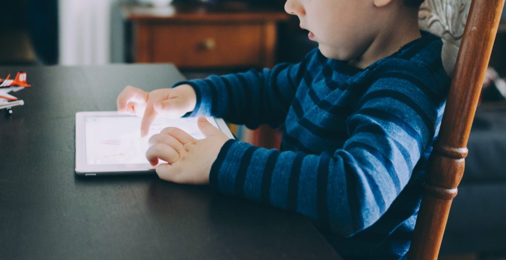 Un enfant utilise une tablette tactile