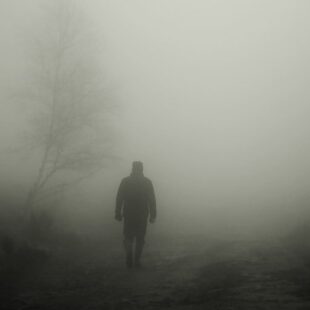 Silhouette d'une personne marchant dans le brouillard.
