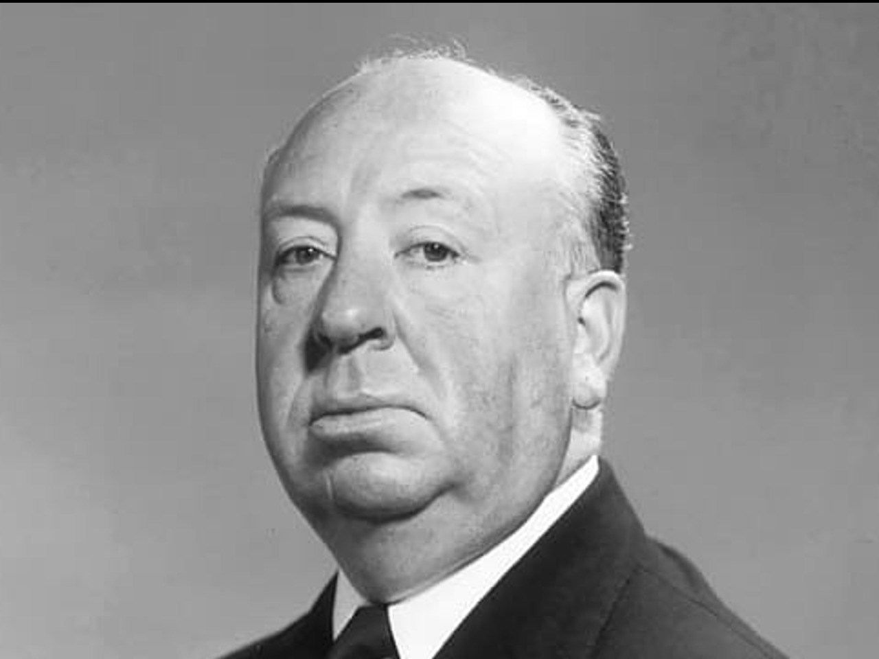 Portrait d'Alfred Hitchcock en noir et blanc.