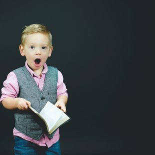 Enfant étonné qui tiens un livre ouvert