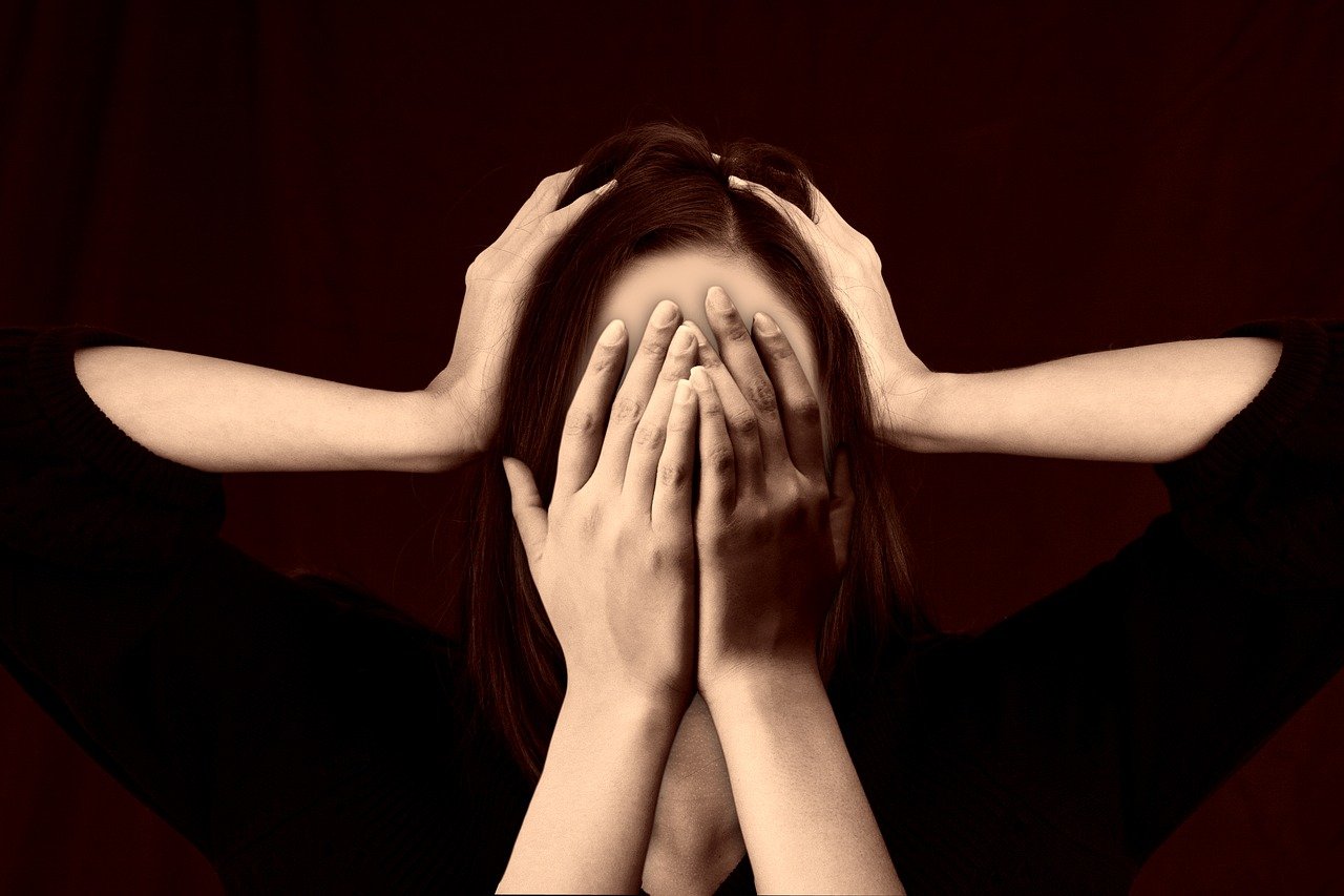 Femme qui se cache les yeux avec les mains