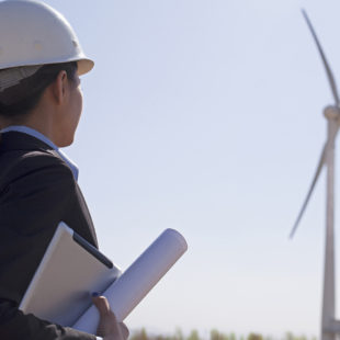 feme ingénieur de profil devant une éolienne