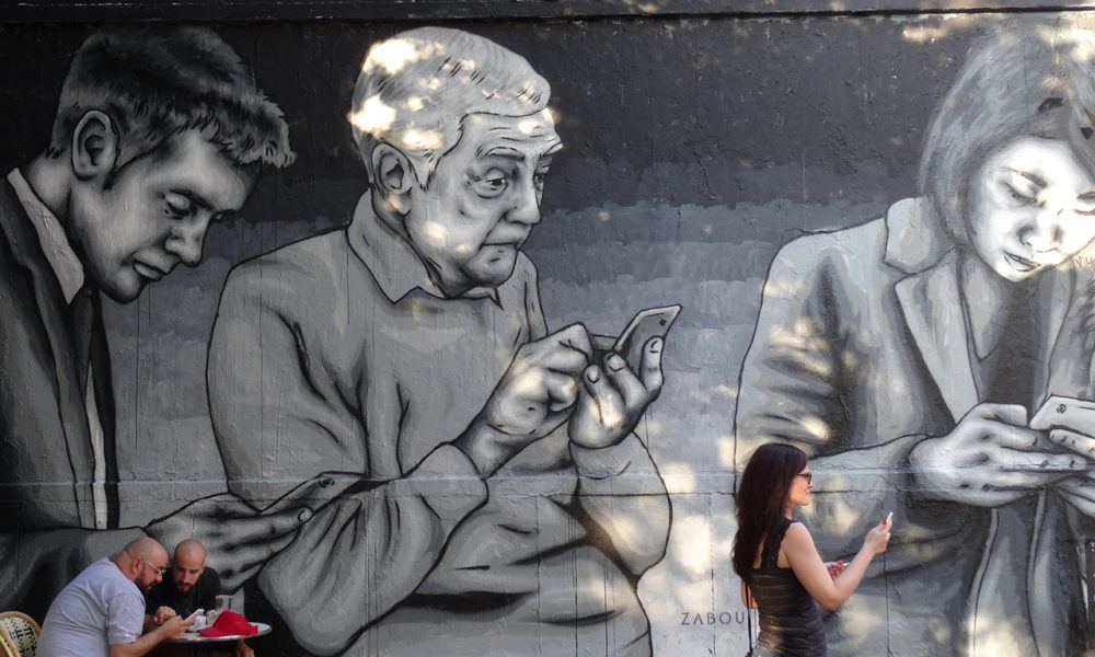 fresque murale représentant des personnes de tous âges sur leurs téléphones portables