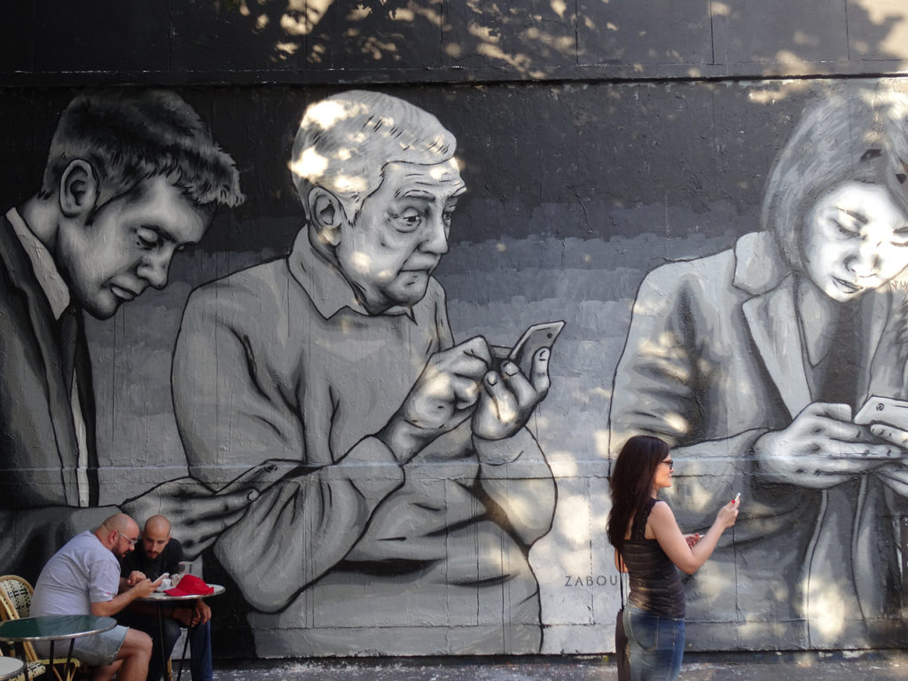 fresque murale représentant des personnes de tous âges sur leurs téléphones portables