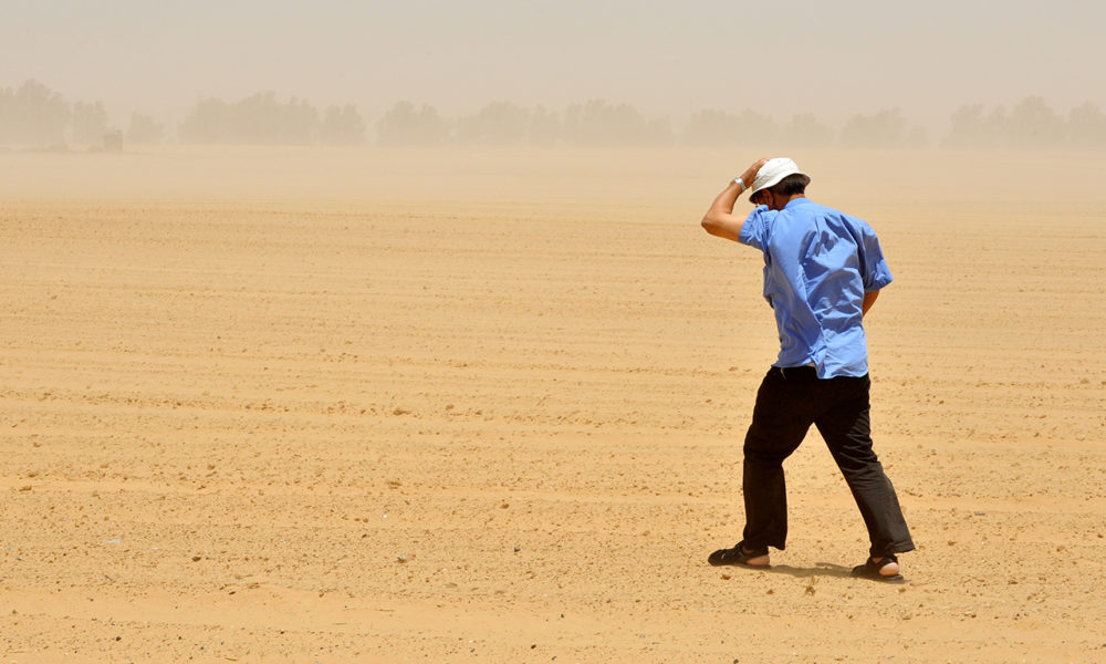 Homme marchant dans une tempête de sable