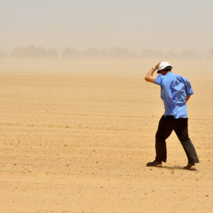 Homme marchant dans une tempête de sable