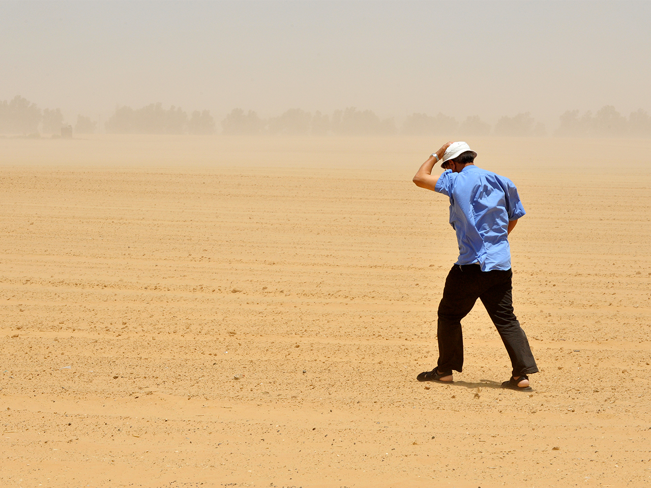 Homme marchant dans une tempête de sable