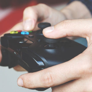 Mains tenant une manette de jeu vidéo