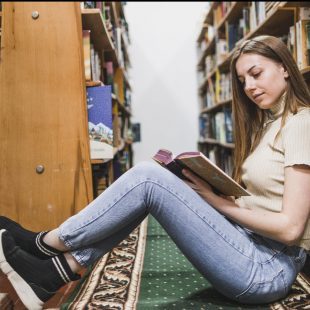 adolescente en train de lire assise par terre