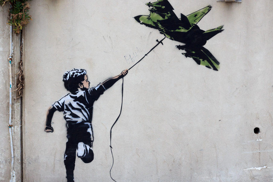 Graffiti d'un enfant avec un avion de chasse en guise de cerf-volant à Tel Aviv