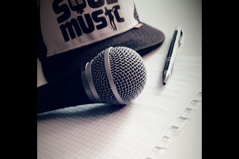 Microphone, papier et stylo sur une table posés à côté d'une casquette