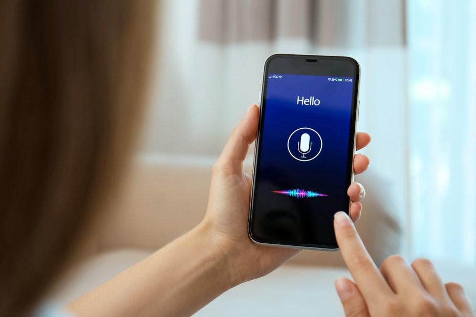 Photographie d'une personne utilisant la reconnaissance vocale sur son téléphone portable