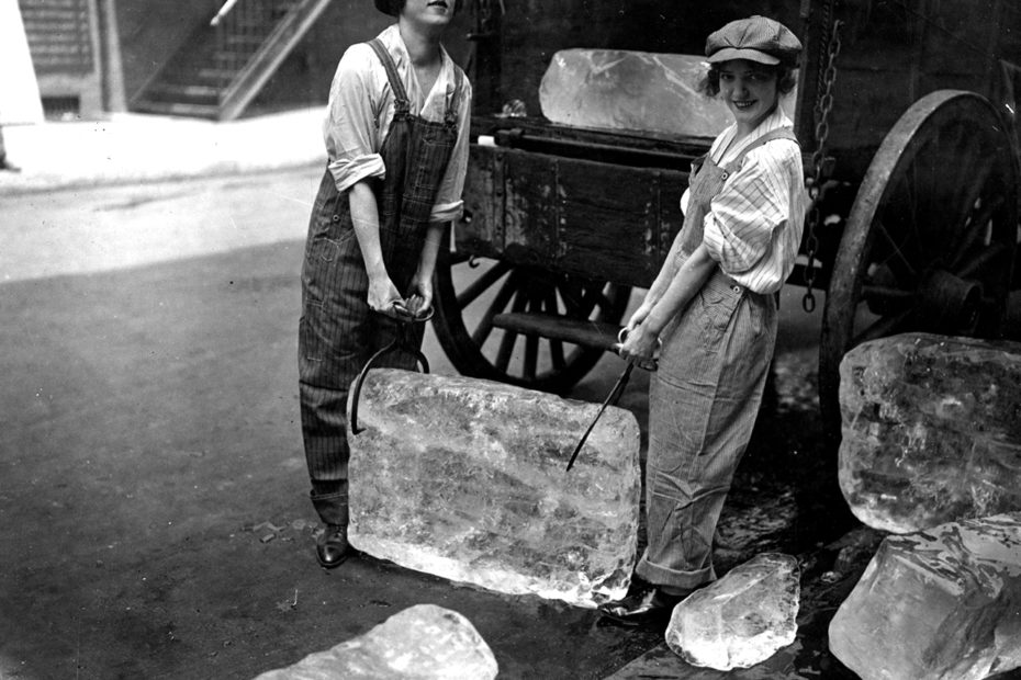 Photographie de deux femmes portant un bloc de glace