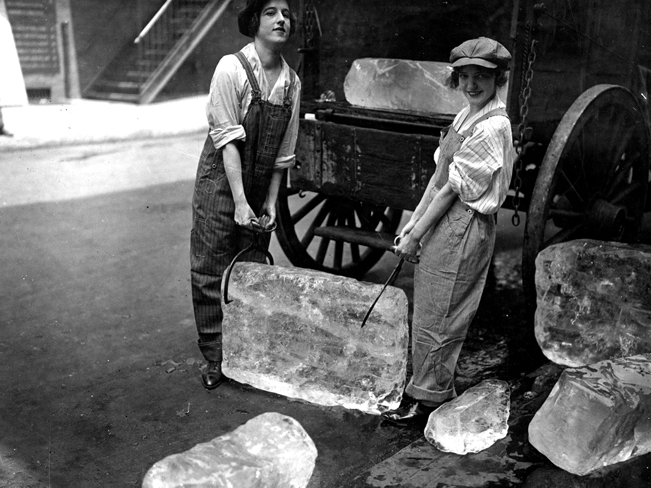 Photographie de deux femmes portant un bloc de glace