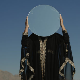personne tenant un miroir davant son visage