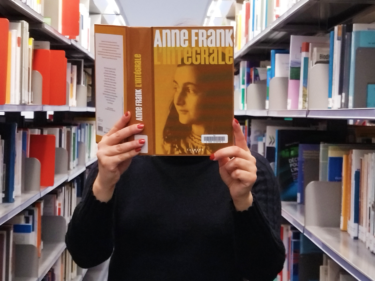 Personne tenant le livre Anne Franck l'intégrale dans les mains