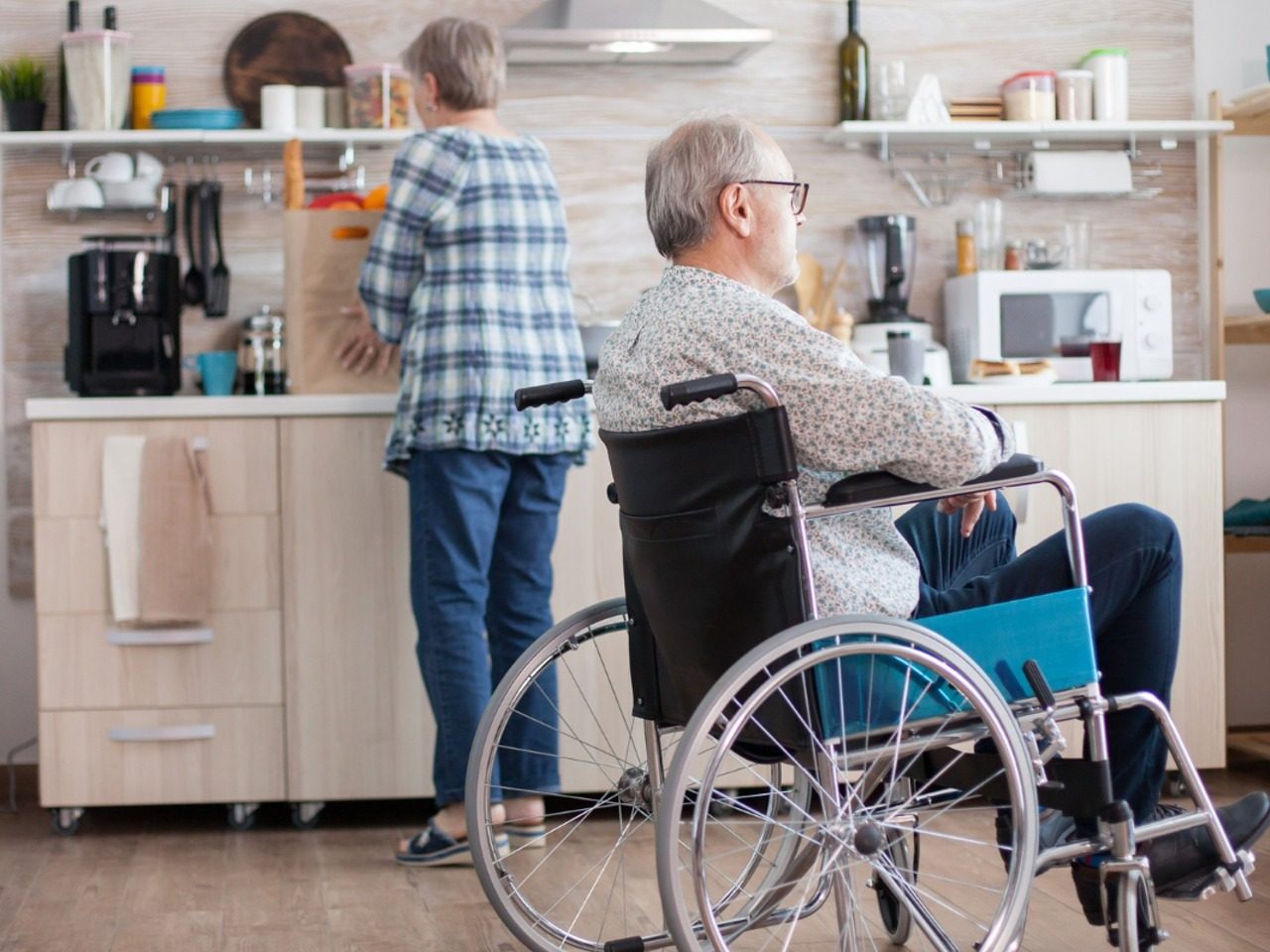 Personne en fauteuil et son aidante dans la cuisine du domicile