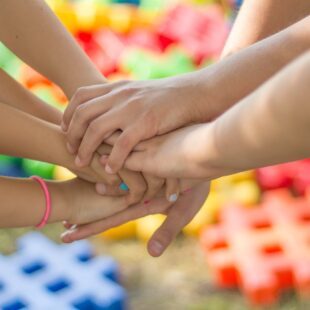 Plusieurs mains d'enfants qui se rejoignent en se superposant