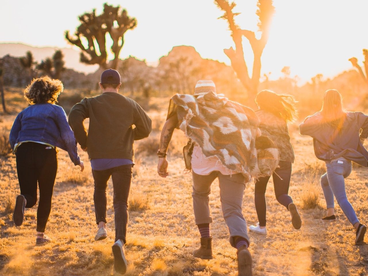 4 adolescents de dos en train de courir