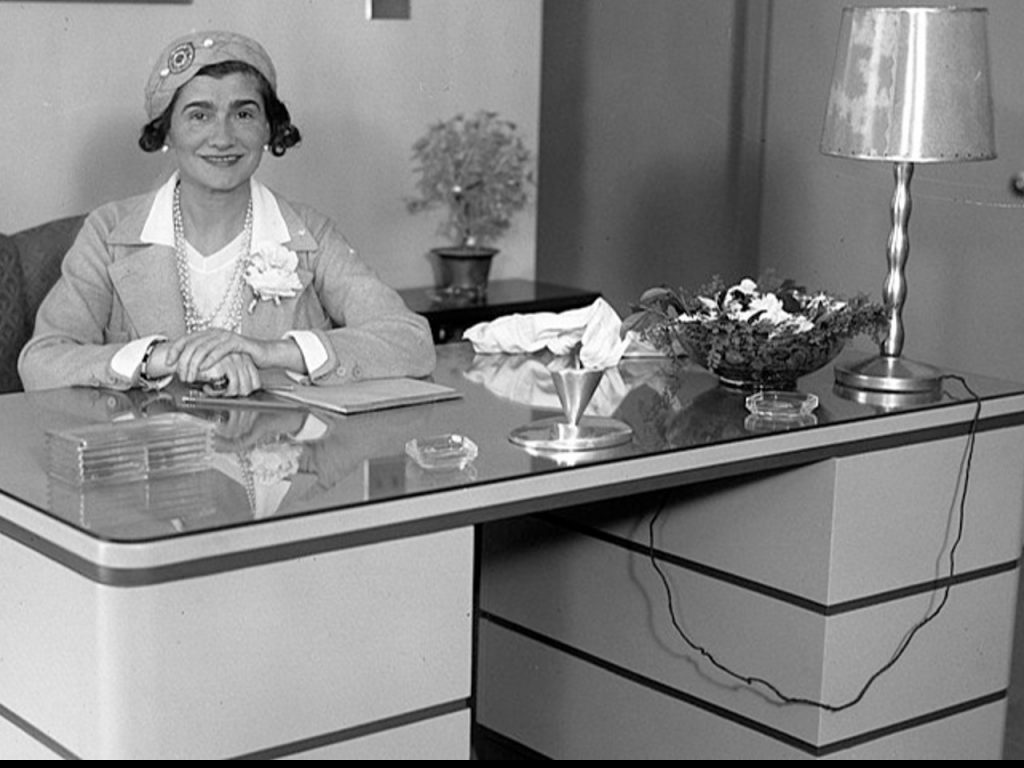 Coco Chanel assise à un bureau lors d'une visite à Los Angeles, le 18 mars 1931