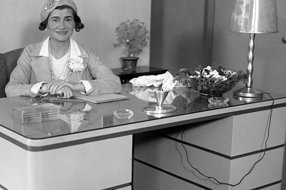 Coco Chanel assise à un bureau lors d'une visite à Los Angeles, le 18 mars 1931