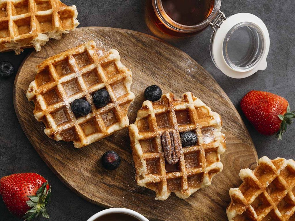 Gaufres au sucre et aux fruits vues de dessus sur plateau en bois