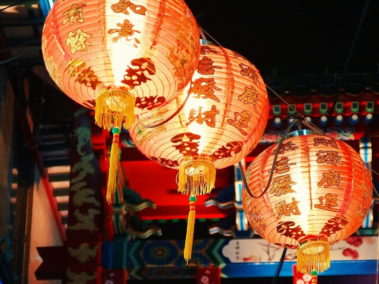 Trois lanternes japonaises allumées.