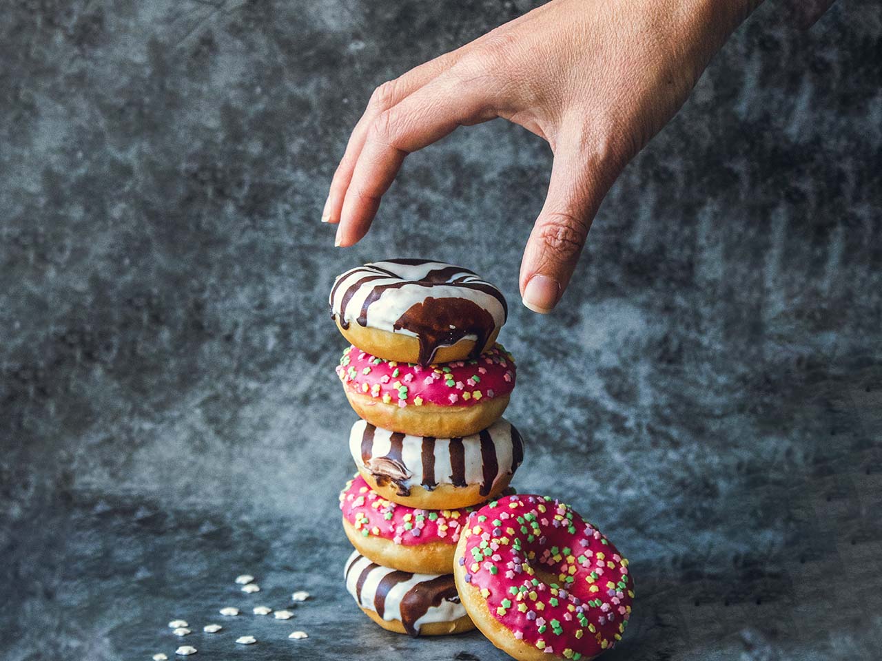 Pile de donuts et main qui prend le premier