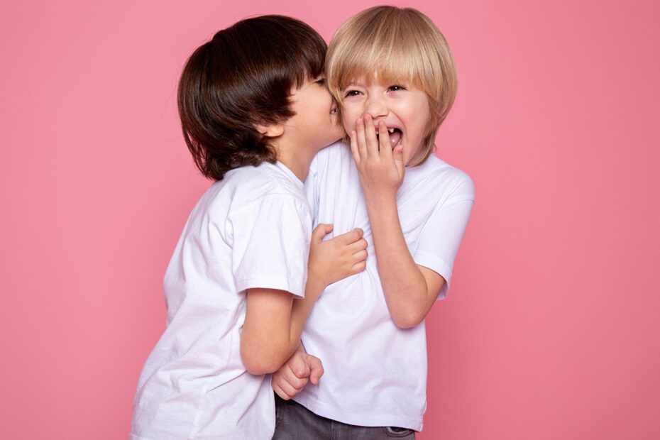 2 enfants riant sur fond rose