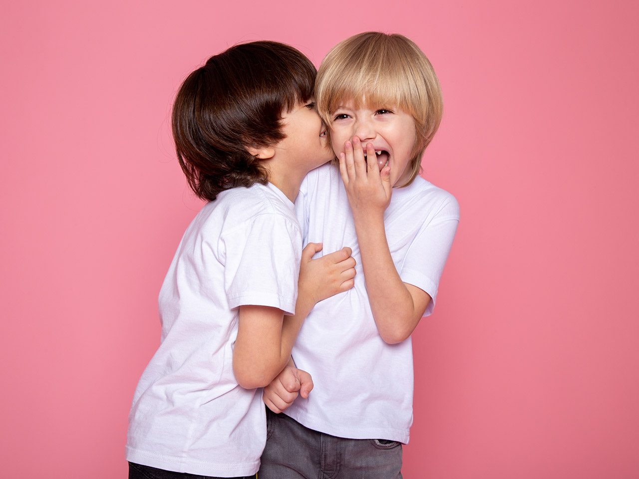 2 enfants riant sur fond rose