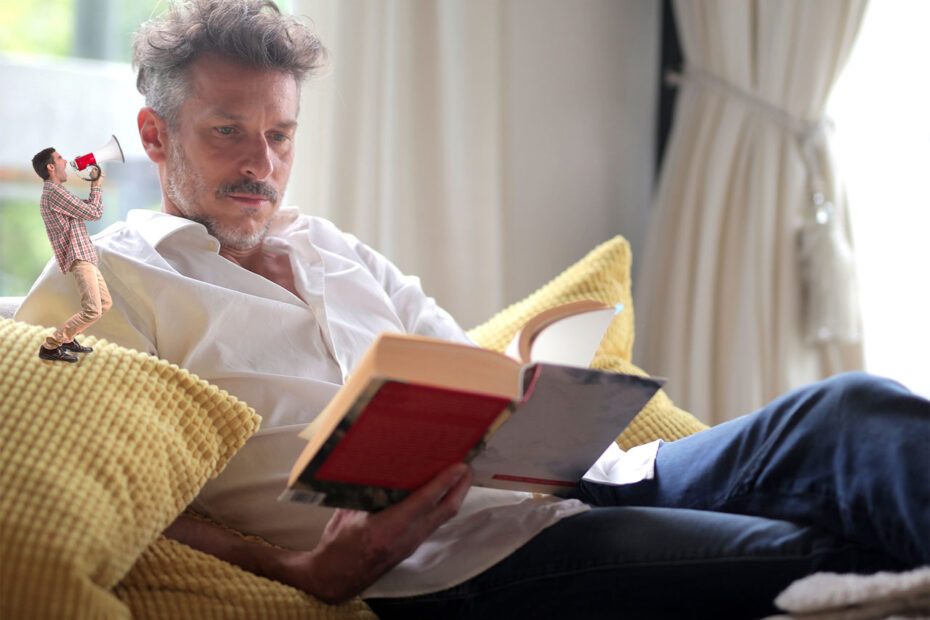 Homme lisant dans un fauteuil avec un personnage miniature lui parlant dans l'oreille à l'aide d'un mégaphone