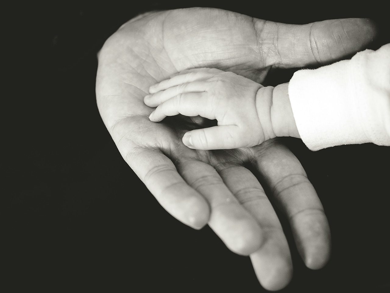 Main de bébé dans main adulte
