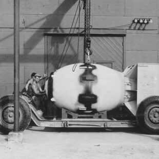 Photographie en noir et blanc de 2 ouvriers travaillant sur Fat man