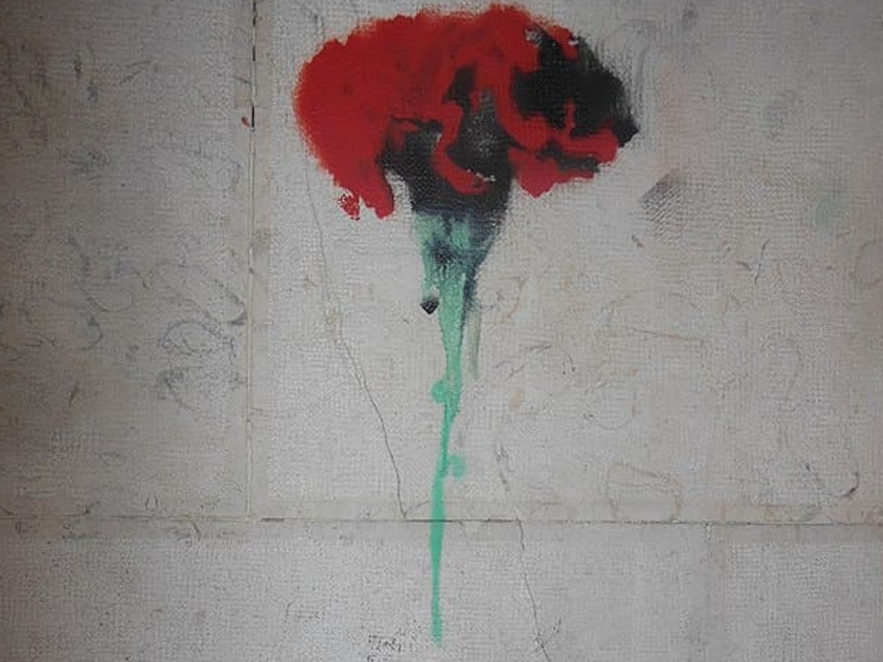 Dessin d'œillet au pochoir sur un mur commémorant le 25 avril 1974, révolution portugaise. Inscription "Fascismo Nunca Mais".