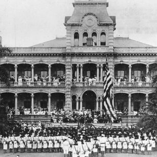 Levée du drapeau américain lors de la cérémonie d'annexion des États-Unis au Palais ʻIolani, à Honolulu, Hawaï. Les marines américains qui participent à la cérémonie appartiennent à l'USS Philadelphia. Collection : Collection Ray Jerome Baker.