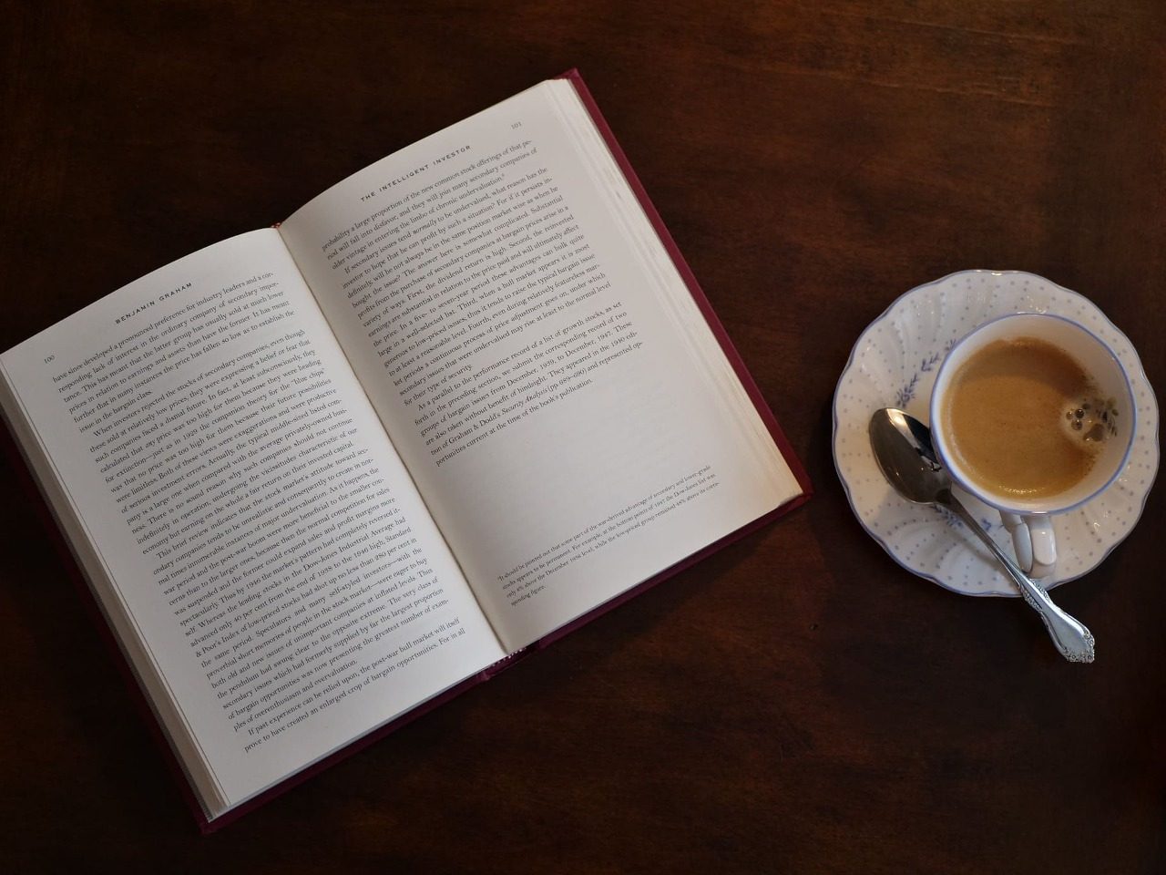 Livre ouvert sur une table à côté d'une tasse de café.