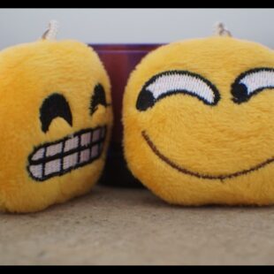 Photo de 2 smiley en peluche qui présentent chacune un rire différent