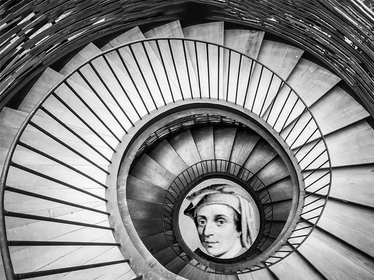 Photographie en noir et blanc montrant un escalier descendant en colimaçon avec au centre le portrait de Fibonaci