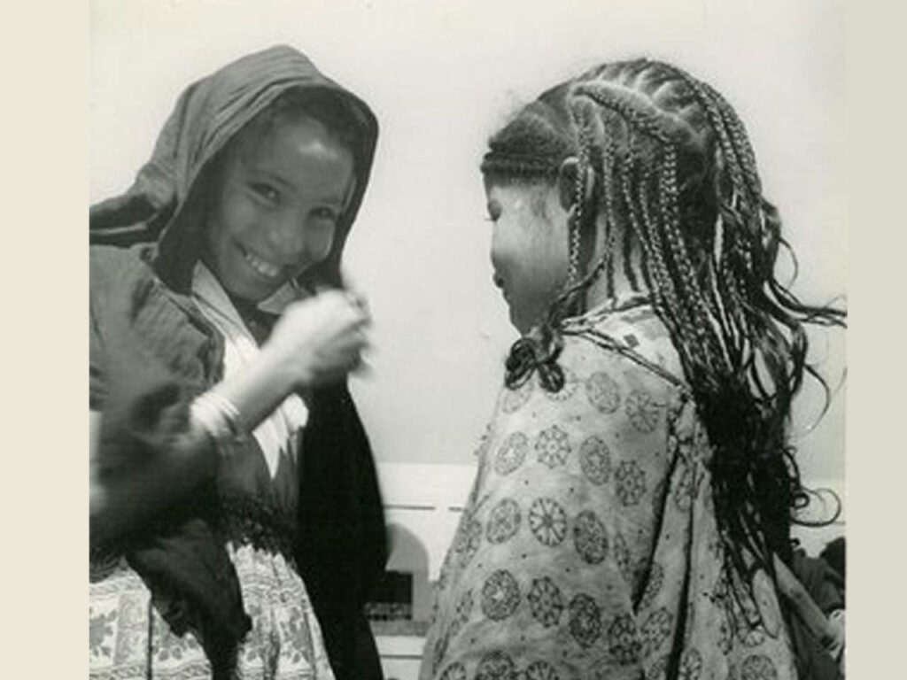 Photographie en noir et blanc de deux jeunes filles berbères dont l'une a les cheveux tressés