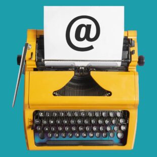 Machine à écrire jaune sur fond bleu pétrole, avec feuille insérée sur laquelle est inscrit en grand le signe arobase.